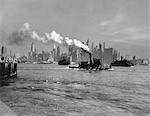 1930s 1933 RETRO STEAM ENGINE TUG BOAT AND STATEN ISLAND FERRY BOATS ON HUDSON RIVER AGAINST MANHATTAN ISLAND SKYLINE NEW YORK CITY USA