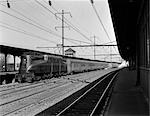 1940s PENNSYLVANIA RAILROAD STREAMLINE ELECTRIC POWERED GG1 LOCOMOTIVE PULLING PASSENGER TRAIN OUT OF STATION