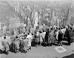 1940s GROUP OF TOURISTS STANDING ON TOP OF RCA BUILDING LOOKING OUT OVER CITY