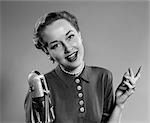 1950s PORTRAIT OF WOMAN SINGING OR SPEAKING AT MICROPHONE RADIO BROADCAST INDOOR