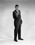 1950s MAN IN BUSINESS SUIT STANDING POINTING FINGER