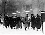 1930s WINTER SNOW CITY STREET SCENE BLURRY MOTION PEOPLE WALKING SNOWY COLD COMMUTING WEATHER BOOTS HATS COATS GLOVES