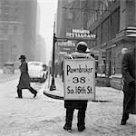 SCÈNE RUE D'HIVER DES ANNÉES 1930 DE PRÊTEUR SUR GAGES HOMME PORTANT HOMME-SANDWICH