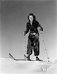 1940s 1930s WOMAN SMILING STANDING ON SKIS HOLDING SKI POLES