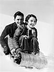 1920s 1930s COUPLE ON SLED IN WINTER