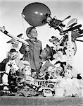 ANNÉES 1950 PÈRE FILS HOLDING BALLON ENTOURÉ DE JOUETS & ANIMAUX EN PELUCHE