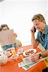 Couple having breakfast and checking classifieds