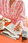 Woman having breakfast and researching classifieds