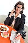 Woman in a wheelchair at breakfast talking on phone