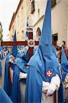 Hooded penitents around a cross in the Holy Week procession in Seville, Andalucia, Spain, Europe