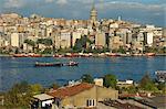 Boats on the Golden Horn, with apartment blocks, commercial buildings and the Galata Tower beyond in Istanbul, Turkey, Europe