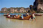 Launching a long tail boat full of backpackers from Railay Beach to Krabi in Thailand, Southeast Asia, Asia