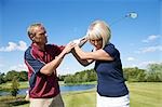 Homme aidant la femme avec son Swing de Golf