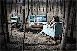 Femme assise dans un meuble de salon Vintage dans une forêt