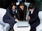 three woman working at laptop together