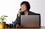 woman sitting at desk talking on phone
