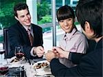 business men exchanging cards while woman looks on