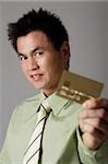 man smiling behind gold credit card