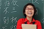 femme riant devant les caractères chinois écrits sur le tableau