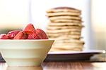 Bowl of Strawberries and Stack of Pancakes