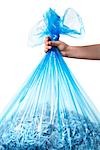 Person Holding Blue Recycling Bag Full of Shredded Paper