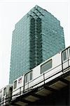 Elevated subway, office building in background, low angle view