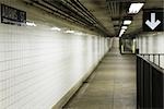 Empty subway corridor, sign directing to street exit