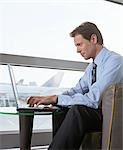 Businessman using Laptop at Airport