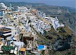 Houses including one with a swimming pool on the hillside in the town of Fira on Santorini (Thira), Cyclades, Greek Islands, Greece, Europe