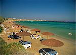 Tourists under sun umbrellas on Golden Beach on Paros, Cyclades, Greek Islands, Greece, Europe