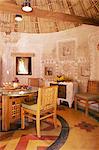 Raised mud reliefs inlaid with mirror on the walls of dining area in modern home in traditional tribal Rabari round mud hut, Bunga style, near Ahmedabad, Gujarat state, India, Asia