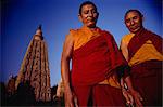 Two Tibetan monks with the main Mahabodhi temple in the background, Bodh Gaya, Bihar state, India, Asia