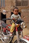 Portrait de jeune enfant assis sur la moto, Katmandou, Népal, Asie
