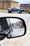 Close-up of Side View Mirror of Vehicle, with Street Scene in Background