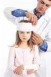 Doctor Wrapping Bandage Around Girl's Head