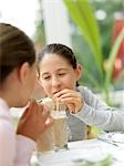 Two girls drinking with straw