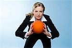 Businesswoman holding ball, front view