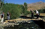 Tourists crossing log bridge, Kakrak valley, Bamiyan, Afghanistan, Asia