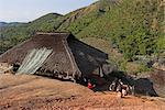 Ann children sliding down mud slope outside thatched house, Ann Village, Kengtung (Kyaing Tong), Shan state, Myanmar (Burma), Asia