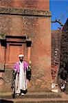 Priest holding cross swings an incense burner at the rock-hewn monolithic church of Bet Giyorgis (St. George's), Lalibela, Ethiopia, Africa