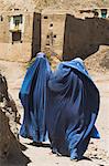 Ladies wearing burqas walk towards houses inside the ancient walls of Citadel, Ghazni, Afghanistan, Asia