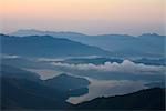 Wolken schweben über See bei Sonnenaufgang, Sikles Trek, Pokhara, Nepal, Asien