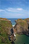 Figures crossing Carrick-A-Rede Bridge over cove, County Antrim, Ulster, Northern Ireland, United Kingdom, Europe