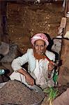Portrait of an elderly shopkeeper with henna dyed beard, smoking a pipe, Djiblah, Yemen, Middle East