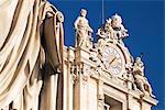 Clock adorning facade of St. Peter's Basilica, with statue of St. Peter in front, Piazza San Pietro, St. Peters, Vatican City, Rome, Lazio, Italy, Europe