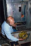 Man shaping cooling molten crystal glass into bowl shape, Orrefors glassworks, Sweden, Scandinavia, Europe