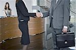 Businessman and woman shaking hands in reception