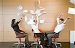 Office workers throwing documents up in the air