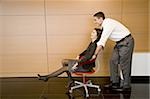 Office worker pushing coworker in office chair