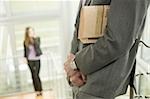 Businessman with financial newspaper on staircase and businesswoman on cell phone